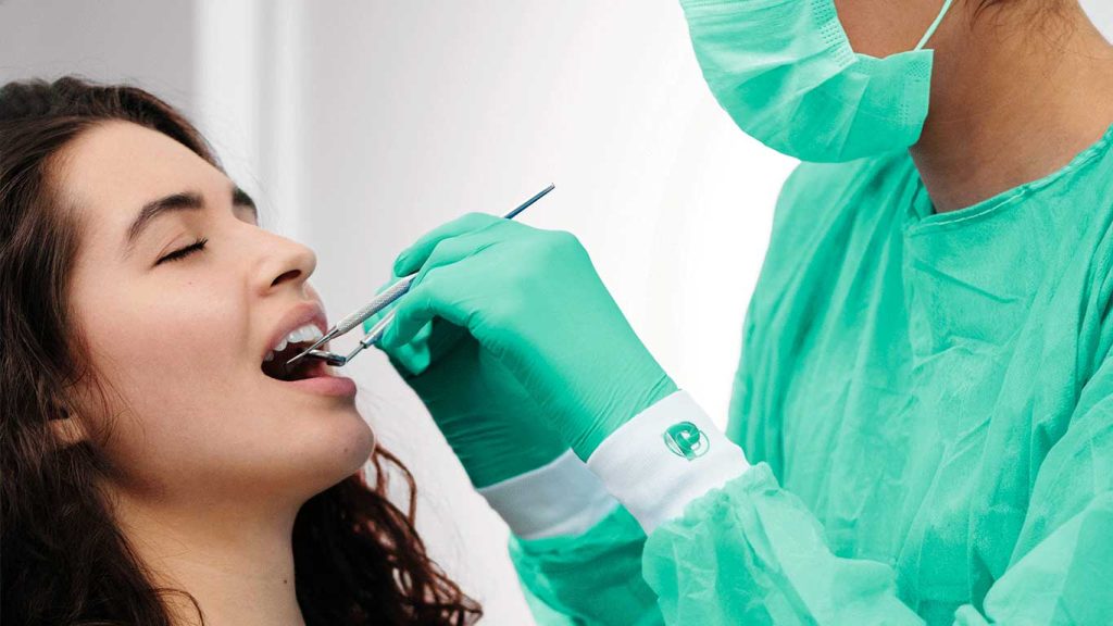 Dentista visita la bocca di una paziente